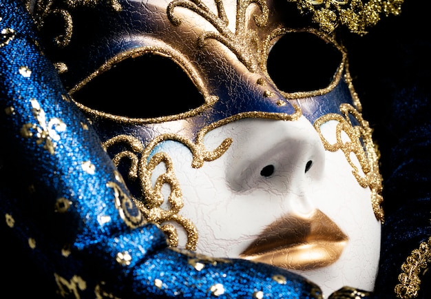 Close up of a blue with gold elegant traditional venetian mask over white background