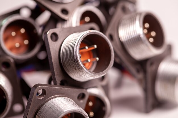 Close-up blurry metal sockets for plugs are in a heap on a white table. Concept for the production of computer televisions and audio speakers