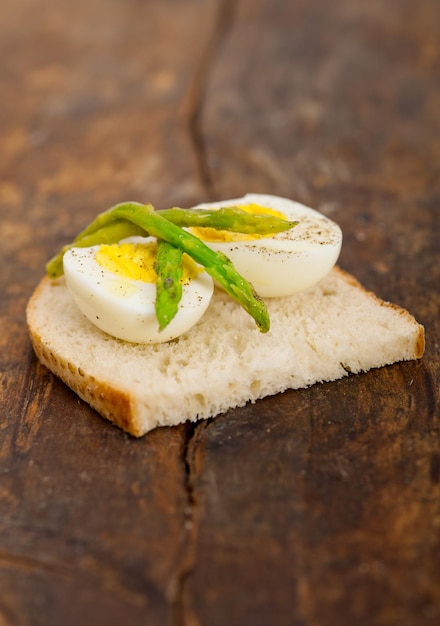 Foto close-up di uova bollite e asparagi sul pane sulla tavola