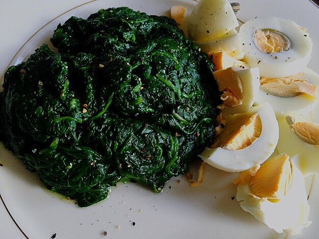 Photo close-up of boiled spinach and eggs served in plate