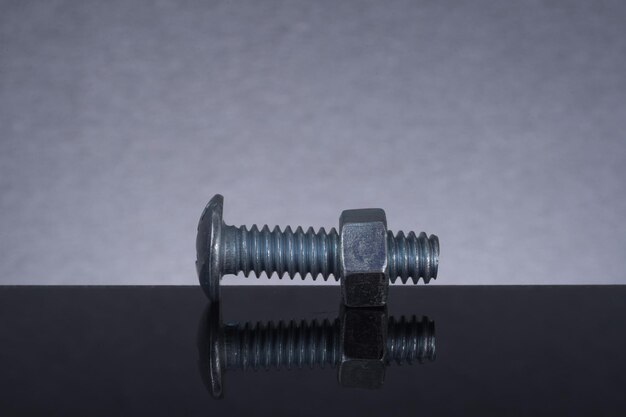 Photo close-up of bolt and screw on table