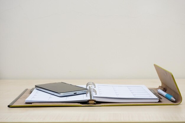 Photo close-up of book and digital tablet on table against white background