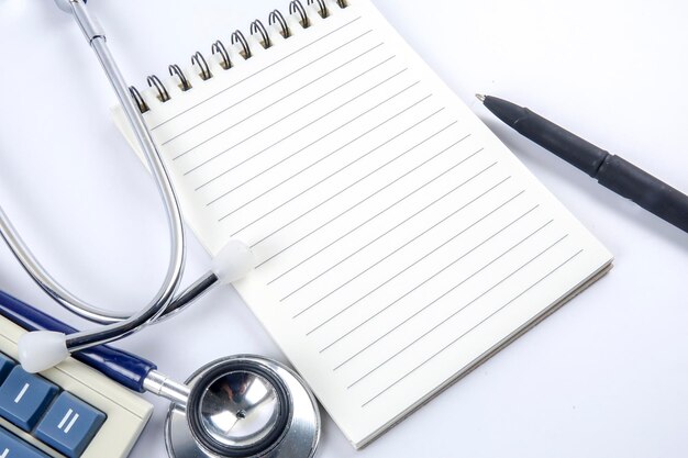 Photo close-up of book with stethoscope and calculator on table