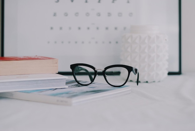 Photo close-up of books with eyeglasses on table