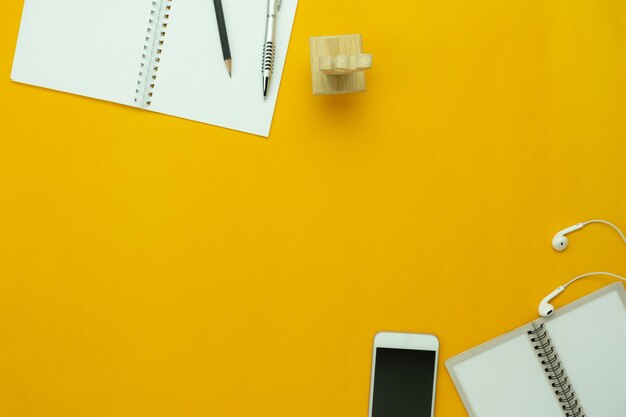 Photo close-up of books with mobile phone over yellow background