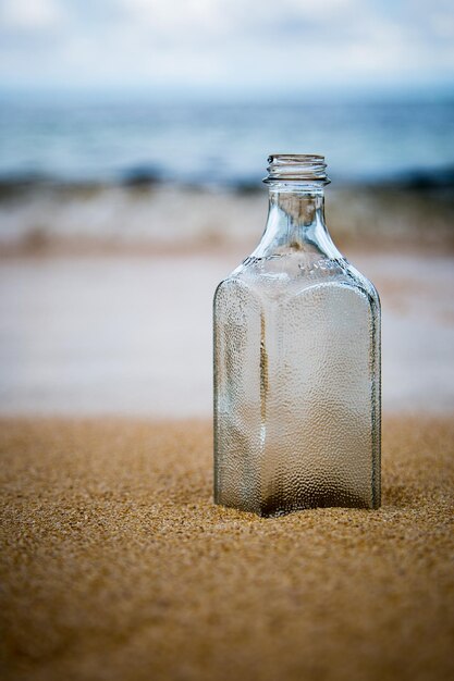 Foto close-up di una bottiglia sul tavolo in spiaggia