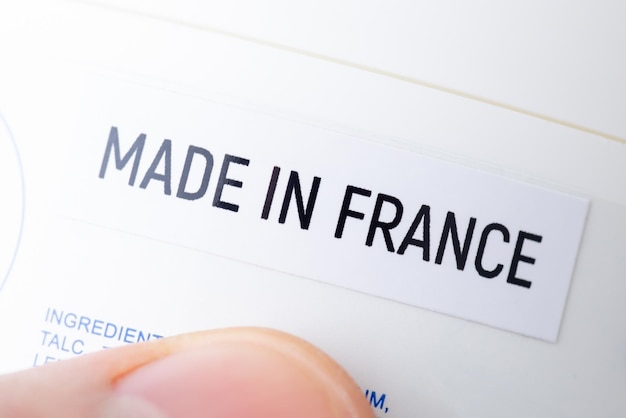 한 남자의 손에 Made in France라는 문구가 새겨진 병을 닫습니다. 프랑스 컨셉의 제품 생산