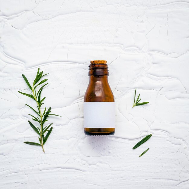 close-up of bottle with rosemary on table