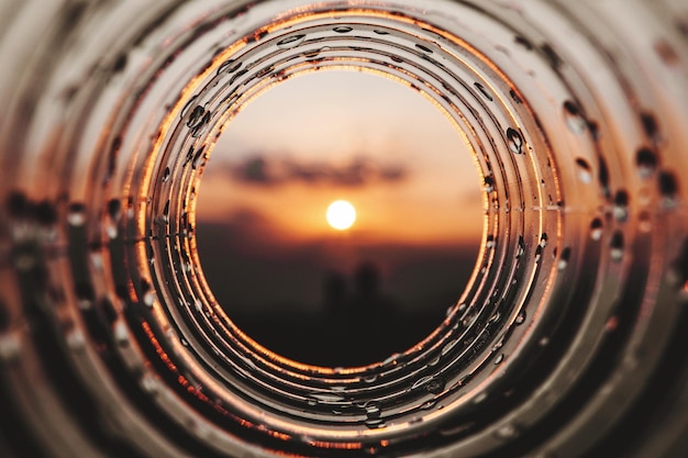 Photo close-up of bottled against sky during sunset