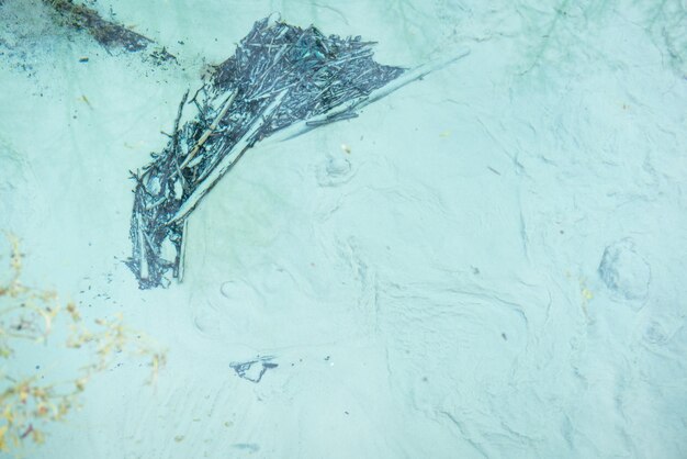 Close up of the bottom of pond with dovecoloured silt and crystal clear water