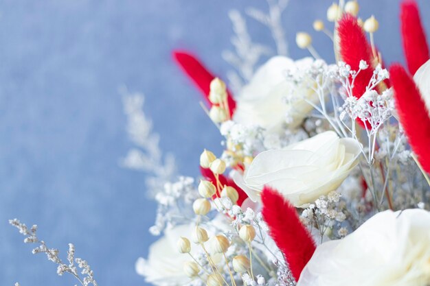 Photo close up on bouquet of colorful dried flowers and white roses