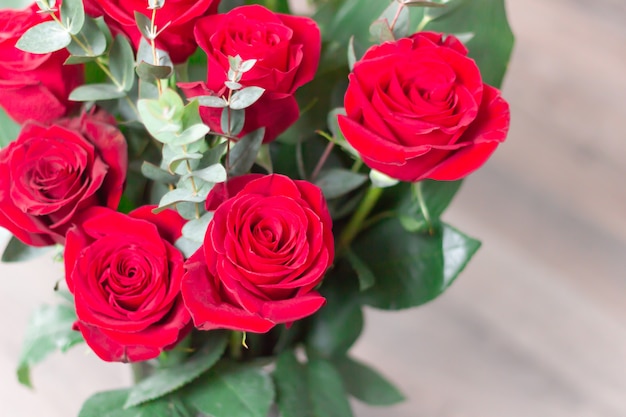 Close-up. Bouquet red Roses on white wooden Background