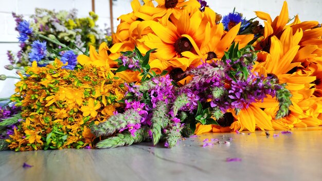 Close-up of a bouquet of wildflowers lies on a table, summer concept, rudbeckia, cornflower, chamaenerion, helichrysum arenarium