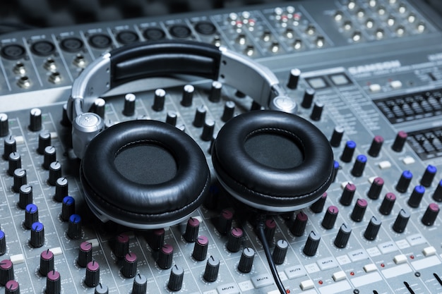 Photo close-up of boutique recording studio control desk, dj headphones for professional disc,  equipment for sound recording studio, mixer and dj headphones