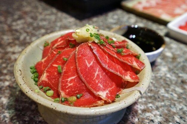 Photo close up bowl of beef tataki raw japanese meat served with citrus soy sauce