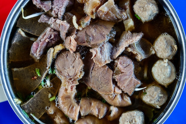 Close up of a bowl of Thai style beef noodle soup.