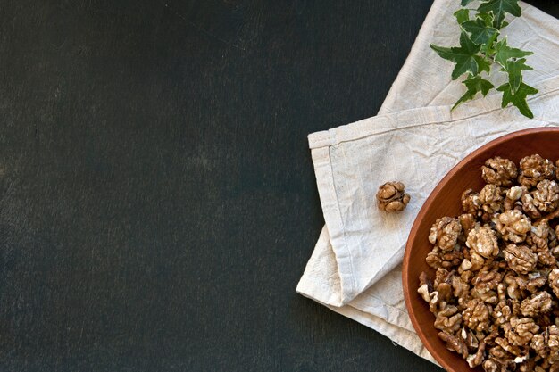 Close-up of a bowl with walnuts on a vintage wooden background. Top view, background.