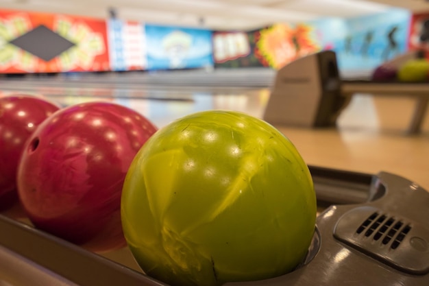 Photo close-up of bowling balls on lane at alley