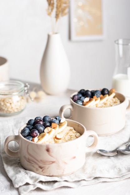 Close up of bowls with oatmeal porridge with blueberries for breakfast