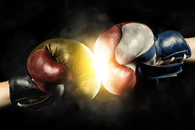 Photo close-up of boxing gloves against black background