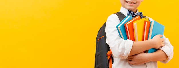 Foto pila di trasporto del ragazzo del primo piano di libri