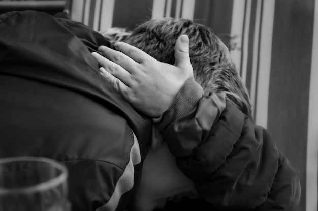 Photo close-up of boy embracing person