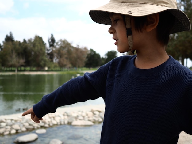 Photo close-up of boy gesturing while wearing sun hat