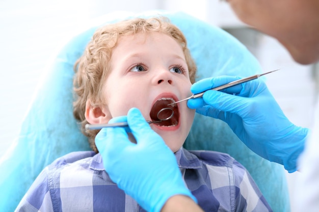 치과 의사가 이빨을 검사하는 소년의 클로즈업.