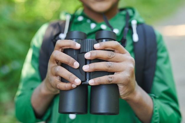 Close-up of boy holding binoculars while travelling outdoors