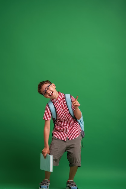 Close up on a boy holding a book in his hands and pointing up