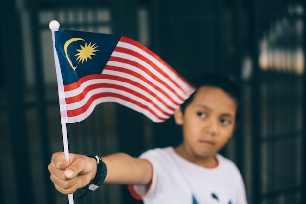 Photo close-up of boy holding malaysian flag