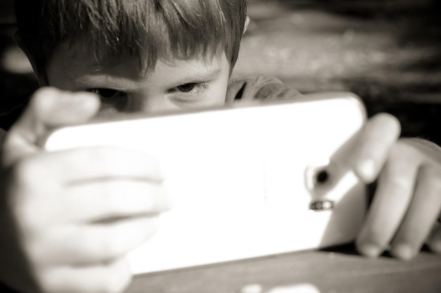 Foto close-up di un ragazzo con un telefono cellulare