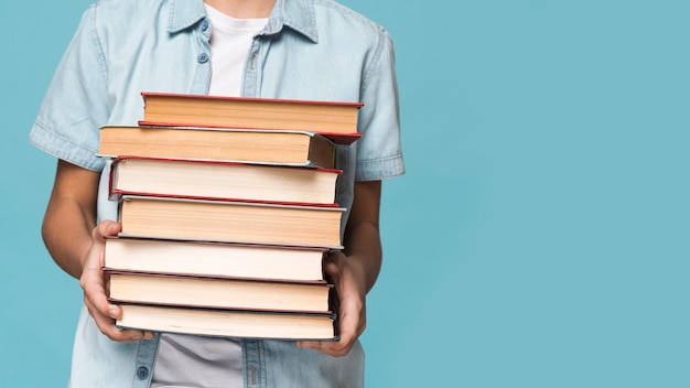 Photo close-up boy holding stack of books