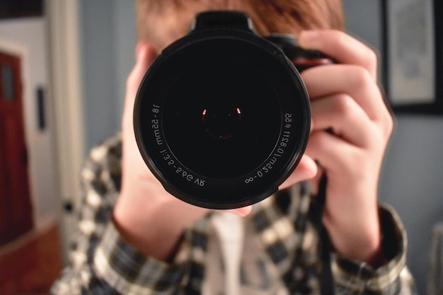 Foto close-up di un ragazzo che guarda attraverso la telecamera