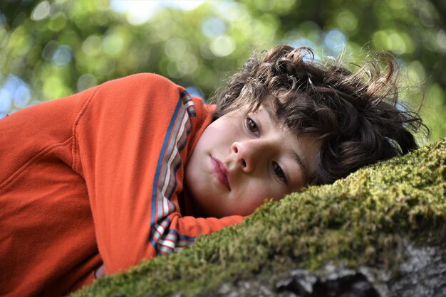 Photo close-up of boy lying on land