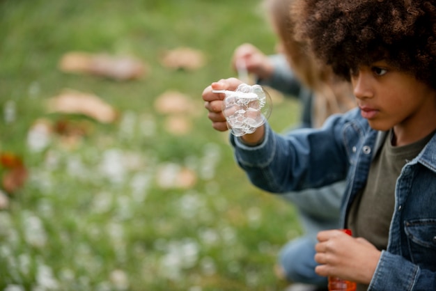 Close up boy making soap bubbles