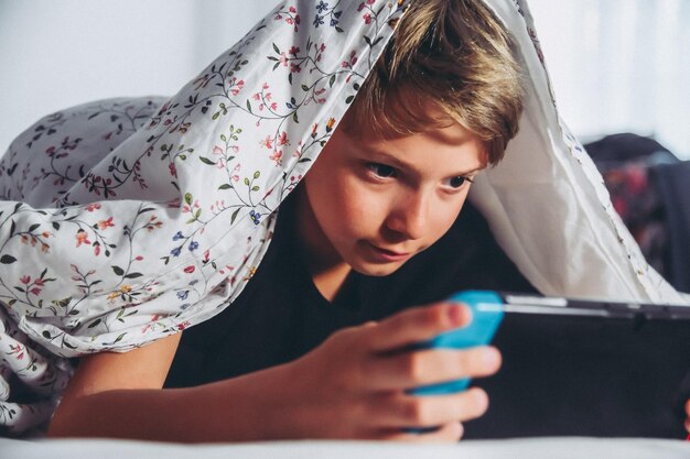 Photo close-up of boy playing on mobile phone