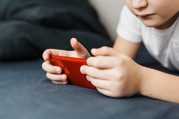 Ragazzo del primo piano che gioca sul telefono cellulare