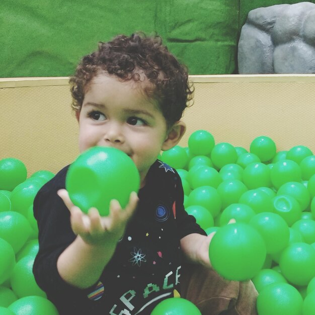 Close-up of boy playing with ball at home