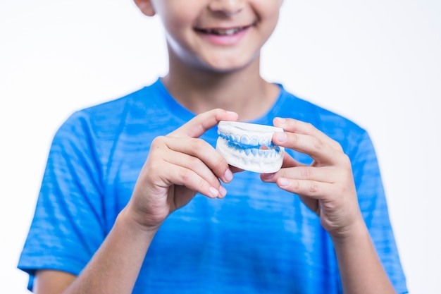 Foto primo piano della muffa dell'intonaco dei denti della tenuta della mano di un ragazzo