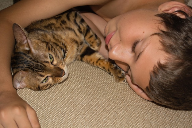 close-up of boy sleeping with cat on bed at home