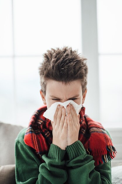 Photo close-up of boy sneezing at home