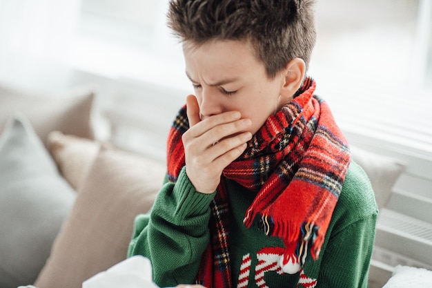Photo close-up of boy sneezing at home