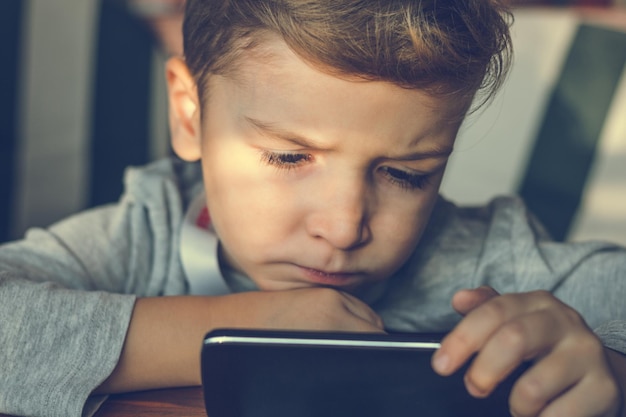 close-up of boy using mobile phone at home