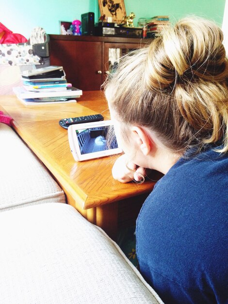 Close-up of boy using mobile phone while sitting on table