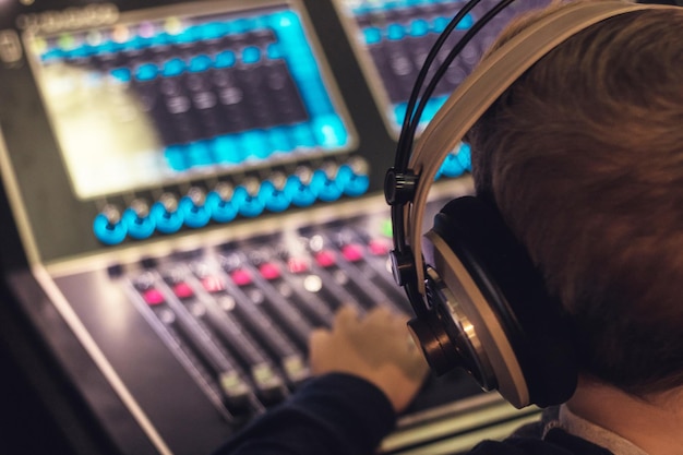 Foto close-up di un ragazzo che usa il mixer in studio