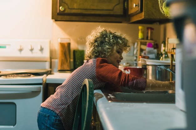 Photo close-up of boy washing hands in kitchen sink