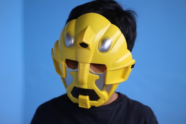 Photo close-up of boy wearing mask against wall