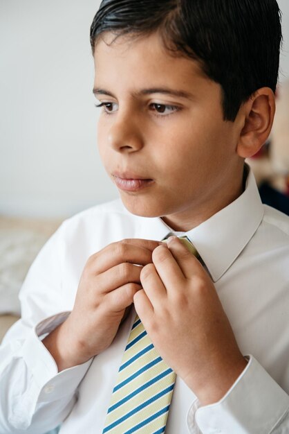 Foto close-up di un ragazzo che indossa l'uniforme scolastica a casa