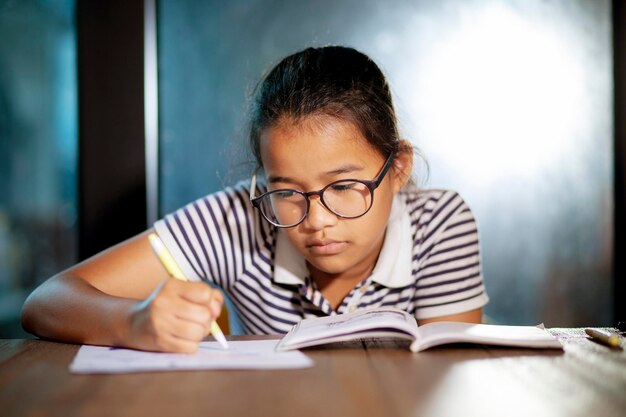 Photo close-up of boy with open book on table